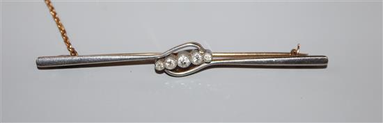 An early 20th century 15ct and graduated five stone diamond set bar brooch, 76mm, gross weight 5.7 grams.